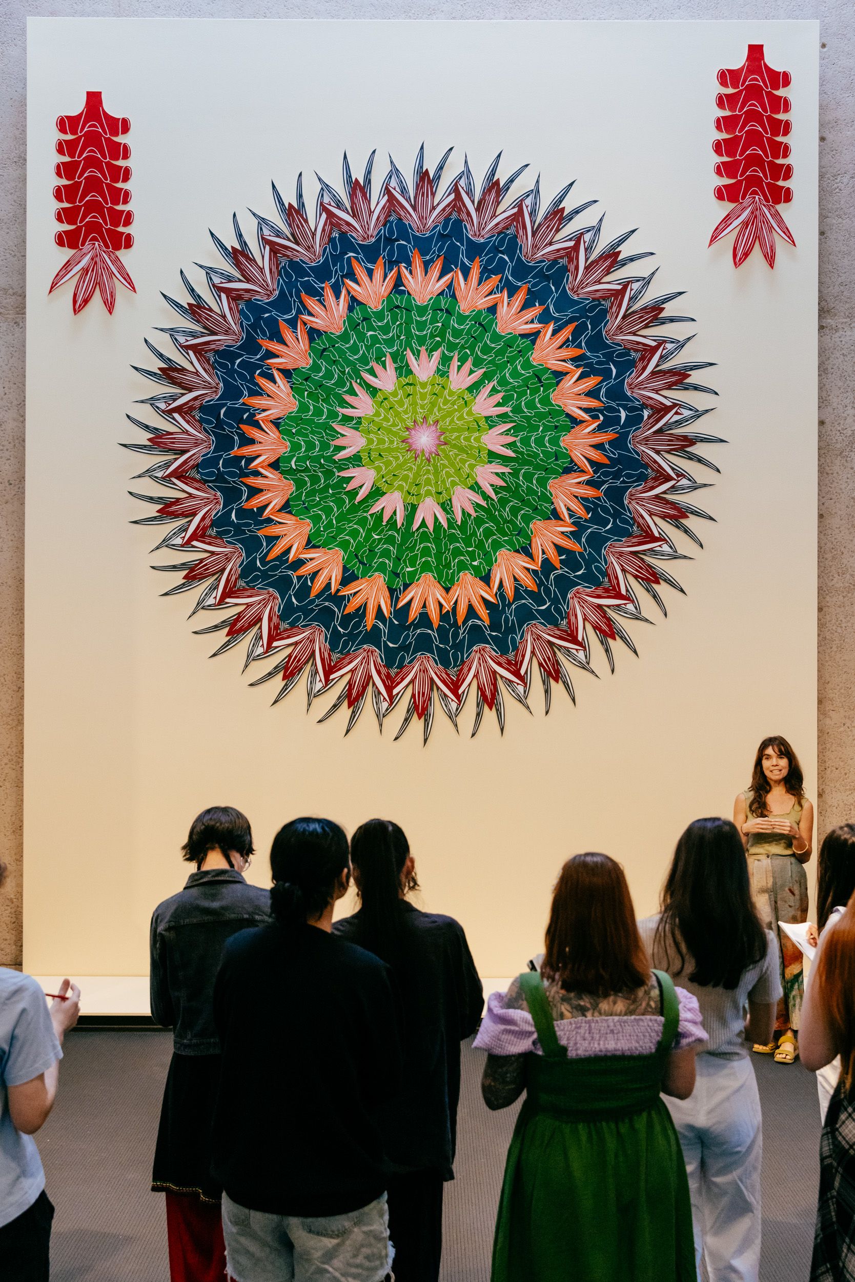 UQ Art Museum Curator Freja Carmichael talking to UQ students in front of artwork
