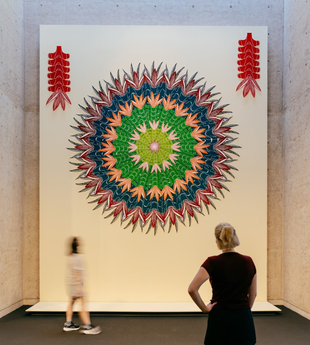 Two visitors standing in front of artwork, 'Wintinganhu (sister-in-law)' by Teho Ropeyarn in UQ Art Museum.